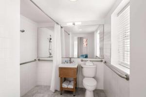 a white bathroom with a toilet and a sink at Townhouse Hotel by LuxUrban in Miami Beach