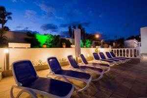 una fila de sillas sentadas en un patio por la noche en Villa Freesia with heated pool and air conditionin en San Miguel de Abona