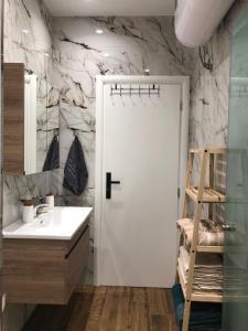 une salle de bain avec une porte blanche et un lavabo dans l'établissement Alajs Apartament, à Vlorë 28 autres photos