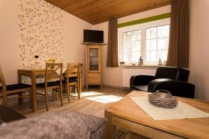 ein Wohnzimmer mit einem Tisch und einem Esszimmer in der Unterkunft Friesenhof Jöns in Garding