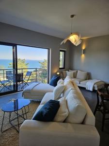 sala de estar con sofá blanco y balcón en Soltroia Beach River & Golf, en Grândola