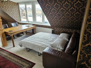 um quarto com uma cama, uma mesa e um sofá em Square apartments em Rokiskis
