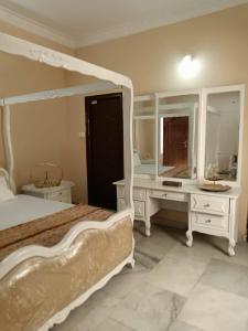 a bedroom with a bed and a desk and mirror at 3-Bedroom Elegant and Spacious AC Apartment only for families, Prime Location, Just 100m from Main Road! in Hyderabad +10 photos