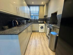 a large kitchen with a washer and dryer at 1-Bedroom Flat in Islington! in London