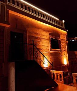 un edificio de piedra con una escalera delante de él por la noche en Rumet paşa konağı en Mardin