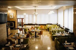 a restaurant with tables and couches and chairs at Хижа Марциганица in Asenovgrad