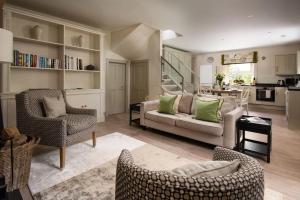 a living room with a couch and chairs and a kitchen at Crailing Coach House in Jedburgh