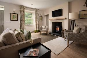 een woonkamer met een bank en een open haard bij Crailing Coach House in Jedburgh