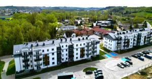 an overhead view of a large white building with a parking lot at Slow River Apartment in Nowe Miasto Lubawskie