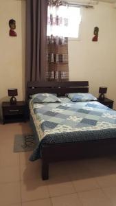 um quarto com uma cama com um edredão azul e uma janela em Le clin d oeil du champ em Sainte-Marie