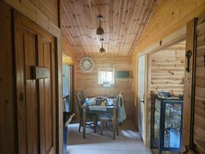 - une salle à manger avec une table dans une cabane en rondins dans l'établissement Domek letniskowy Zacisze, à Świętne