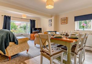 a living room with a dining room table and a couch at Hidden Loke Cottage in Blakeney