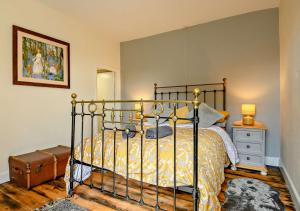 a bedroom with a bed with a metal bed frame and a night stand at Hidden Loke Cottage in Blakeney