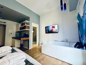 a bathroom with a tub and a tv on the wall at Residenze Chamur- Grattacielo in Palermo