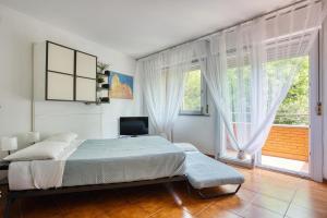 a bedroom with a bed and a large window at Domus Parnaso - Eur in Rome