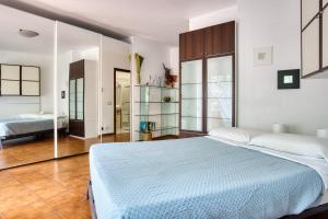 a white bedroom with a bed and a mirror at Domus Parnaso - Eur in Rome