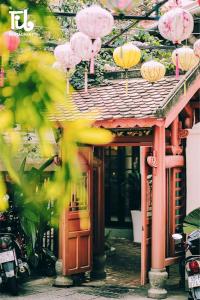 ein Gebäude mit rosa und gelben Sonnenschirmen darüber in der Unterkunft LUCY HOTEL & APARTMENT in Ho-Chi-Minh-Stadt