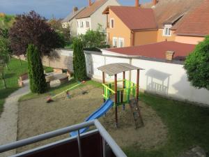 um parque infantil com um escorrega num quintal em Zafír Sziget Apartman em Sárvár