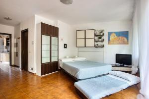 a bedroom with two beds and a flat screen tv at Domus Parnaso - Eur in Rome