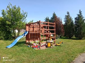 a playground with a blue slide in the grass at Przystań w Jezierzanach in Jezierzany