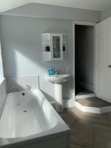uma casa de banho branca com uma banheira e um lavatório em Marshfield House em Goole