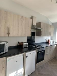 a kitchen with white appliances and wooden cabinets at Marshfield House in Goole