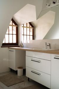 a kitchen with white cabinets and a sink at Apartament Portowy in Mikołajki