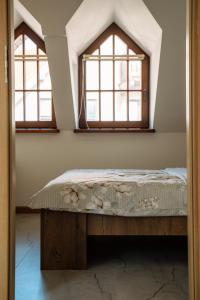 a bedroom with two windows and a bed at Apartament Portowy in Mikołajki