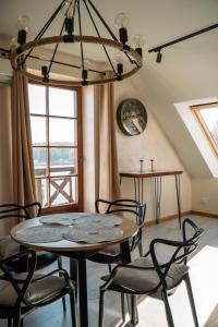 ein Esszimmer mit einem Tisch, Stühlen und einem Kronleuchter in der Unterkunft Apartament Portowy in Mikołajki