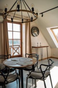 a dining room with a table and chairs and a chandelier at Apartament Portowy in Mikołajki