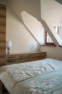 ein Schlafzimmer mit einem Bett und einer weißen Wand in der Unterkunft Apartament Portowy in Mikołajki