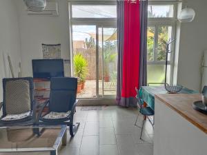 eine Küche mit einem Tisch, 2 Stühlen und einem Fenster in der Unterkunft Quetzal in Perpignan