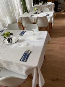 a group of tables with white tables and chairs at Haven - Hotel Am Stadion in Leverkusen