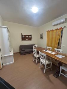 ein Wohnzimmer mit einem Tisch, Stühlen und einem Sofa in der Unterkunft La casina di Karol in Ronciglione
