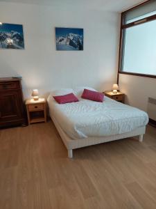 a bedroom with a bed with two red pillows at Le chitelet rouge, Hohneck in La Bresse