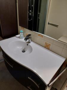 a bathroom with a white sink and a mirror at Le chitelet rouge, Hohneck in La Bresse