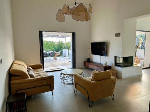ein Wohnzimmer mit 2 Sofas und einem TV in der Unterkunft La Villa Gioia avec piscine ! in 
