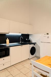 La cuisine est équipée de placards blancs, d'un évier et d'un lave-vaisselle. dans l'établissement Andromeda Luxury Flat, à Modugno