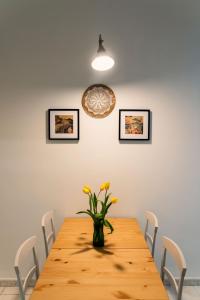 une table à manger avec des fleurs jaunes dans un vase dans l'établissement Andromeda Luxury Flat, à Modugno