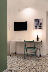 Cette chambre comprend un bureau et une télévision murale. dans l'établissement Andromeda Luxury Flat, à Modugno