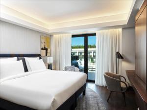 a hotel room with a bed and a balcony at Athens Capital Center Hotel - MGallery Collection in Athens