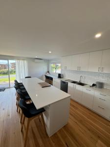 a kitchen with white cabinets and a white counter top at Eden Explorer - Beach - Bike - Hike - Fish in Eden