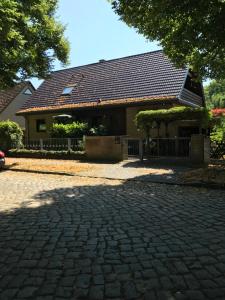a house with a brick driveway in front of it at Stadtnahe Unterkunft im Grünen in Berlin