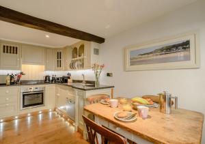 a kitchen with a wooden table with food on it at Parsley Cottage in Blakeney