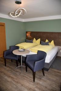 - une chambre avec un lit, une table et des chaises dans l'établissement Pension Langerspacher, à Grabenstätt