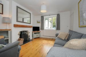 a living room with a couch and a fireplace at Hobbs Cottage in Okehampton