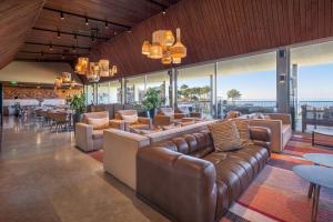 a lobby with leather couches and tables and windows at Immerso Hotel, a Member of Design Hotels in Ericeira