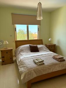 - une chambre avec un grand lit et une fenêtre dans l'établissement Apartament na Cyprze, à Peyia