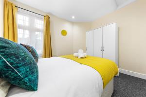 una camera con letto e armadio giallo e bianco di 2 bedroom flat with a king-size bed in London, United Kingdom a Barnet