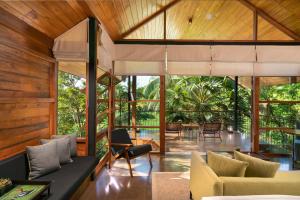 una sala de estar de planta abierta con vistas al bosque. en Taru Villas Maia - Habarana en Habarana